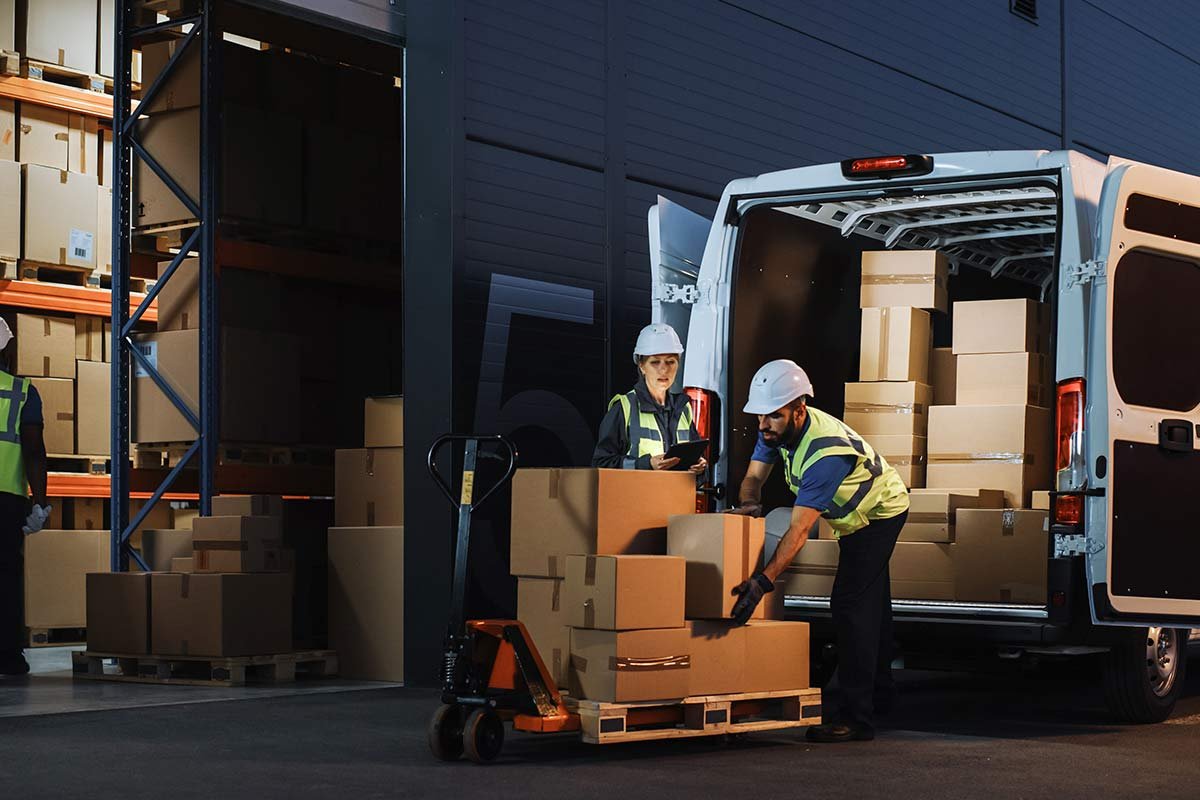 Man and Women are loading the packed boxes on the truck
